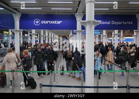 Passagiere stehen am Eingang zum Eurostar in der St Pancras International Station im Zentrum von London an. Eurostar hat angekündigt, dass alle seine Dienste am Sonntag wieder aufgenommen werden, nachdem die Überschwemmungen in Tunneln unter der Themse unter Kontrolle gebracht wurden, obwohl Geschwindigkeitsbeschränkungen zu Verzögerungen führen können. Bilddatum: Sonntag, 31. Dezember 2023. Stockfoto