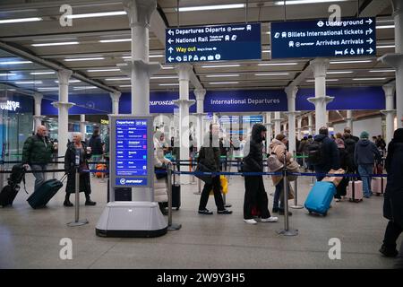 Passagiere stehen am Eingang zum Eurostar in der St Pancras International Station im Zentrum von London an. Eurostar hat angekündigt, dass alle seine Dienste am Sonntag wieder aufgenommen werden, nachdem die Überschwemmungen in Tunneln unter der Themse unter Kontrolle gebracht wurden, obwohl Geschwindigkeitsbeschränkungen zu Verzögerungen führen können. Bilddatum: Sonntag, 31. Dezember 2023. Stockfoto