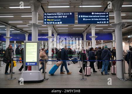 Passagiere stehen am Eingang zum Eurostar in der St Pancras International Station im Zentrum von London an. Eurostar hat angekündigt, dass alle seine Dienste am Sonntag wieder aufgenommen werden, nachdem die Überschwemmungen in Tunneln unter der Themse unter Kontrolle gebracht wurden, obwohl Geschwindigkeitsbeschränkungen zu Verzögerungen führen können. Bilddatum: Sonntag, 31. Dezember 2023. Stockfoto