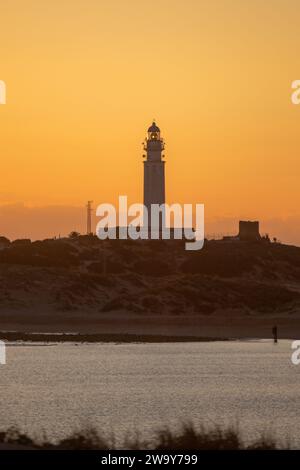 Der Leuchtturm am Strand mit einem klaren Sonnenuntergang. Der Leuchtturm befindet sich in der Küstenstadt Caños de Meca in Südspanien Stockfoto