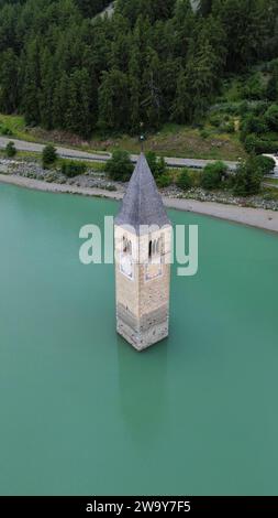 Luftbilddrohne des Reschensees (Reschensee mit untergetauchtem Kirchturm in Kurven, Südtirol, Italienische Alpen, Italien. Stockfoto