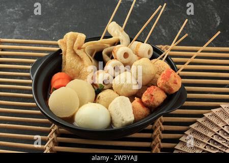 Japanische hausgemachte Oden Fish Ball Fstive Suppe mit Dashi Stock, serviert auf Black Nabe Stockfoto