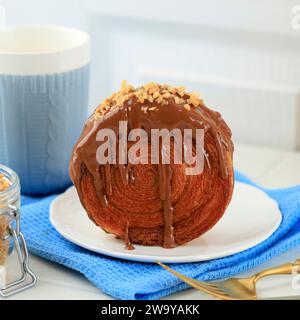 Cromboloni, Croissant Bomboloni. Runden Sie New York Roll mit Schokoladensauce und gehackten Erdnüssen ab Stockfoto