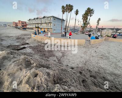 Dezember 30, 2023, Santa Barbara/Ventura, Kalifornien, USA: 30. Dezember, bei Ebbe: Dutzende von Menschen aus ganz Südkalifornien machten sich auf den Weg, um dem Ort in Ventura zu huldigen, wo ein â œRogue€ Monster waveâ€ am Donnerstag, 28. Dezember, in Pierpont, Ventura über Sand und Straße schlängelte. fast ein Dutzend Menschen die Straße hinunter gefegt und viele verletzt. die Straßen wurden geputzt, sind aber immer noch schlammig und feucht, und eine Sanddüne wurde von den Crews des County of Ventura gebaut, um zu verhindern, dass weitere Häuser und Geschäfte beschädigt werden: es werden mehr große Wellen und Überschwemmungen erwartet Stockfoto