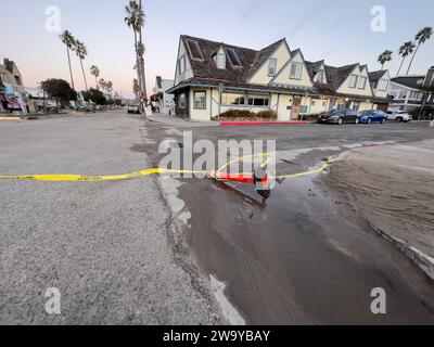 Dezember 30, 2023, Santa Barbara/Ventura, Kalifornien, USA: 30. Dezember, bei Ebbe: Dutzende von Menschen aus ganz Südkalifornien machten sich auf den Weg, um dem Ort in Ventura zu ehren, wo am Donnerstag, 28. Dezember, in Pierpont, Ventura, eine „Schurkenmonsterwelle“ über Sand und Straße schlängelte. fast ein Dutzend Menschen die Straße hinunter gefegt und viele verletzt. die Straßen wurden geputzt, sind aber immer noch schlammig und feucht, und eine Sanddüne wurde von den Crews des County of Ventura gebaut, um zu verhindern, dass weitere Häuser und Geschäfte beschädigt werden: es werden mehr große Wellen und Überschwemmungen erwartet Stockfoto