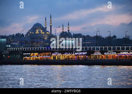 Istanbul, Türkei - 11. Dezember 2023: Blick vom Bosporus auf die Galata-Brücke und die Suleiman- oder Suleymaniye-Moschee am Winterabend Stockfoto