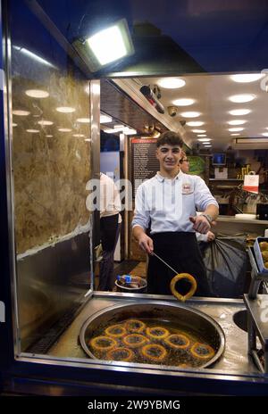 Istanbul, Türkei - 12. Dezember 2023: Ein Koch zeigt die traditionellen Halka Tatlisi oder türkischen Churros in einem Street Food Shop. Eine knusprige und süße Straße Stockfoto