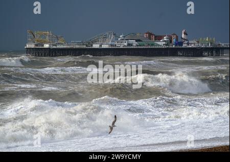 Wellen brechen an der Küste und um den Pier in Brighton, East Sussex. Für Teile Englands und Wales wurde für Silvester eine Wetterwarnung vor Wind ausgegeben, während in anderen Teilen des Vereinigten Königreichs Nachtschwärmer dazu aufgefordert wurden, für den Countdown eine Regenjacke einzupacken. Bilddatum: Sonntag, 31. Dezember 2023. Stockfoto