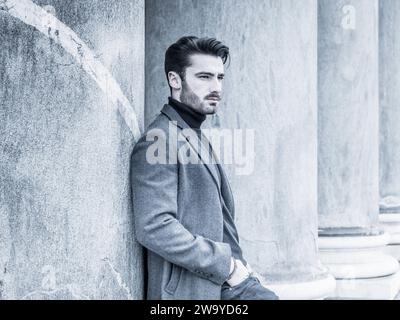 Gut aussehender bärtiger junger Mann outdoor im Winter Mode, mit schwarzen rollkragen pullover und woolen Blazer Jacke in Stadt Einstellung Stockfoto