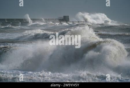 Wellen brechen gegen den Wellenbrecher in Brighton Marina in Brighton, East Sussex. Für Teile Englands und Wales wurde für Silvester eine Wetterwarnung vor Wind ausgegeben, während in anderen Teilen des Vereinigten Königreichs Nachtschwärmer dazu aufgefordert wurden, für den Countdown eine Regenjacke einzupacken. Bilddatum: Sonntag, 31. Dezember 2023. Stockfoto