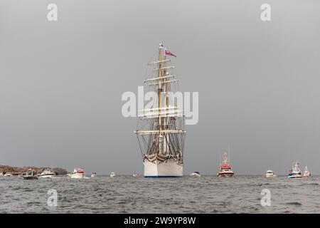 Lindesnes, Norwegen - 07. August 2021: Segelschulschiff Statsraad Lehmkuhl wird von einer Armada kleiner Boote begrüßt. Stockfoto