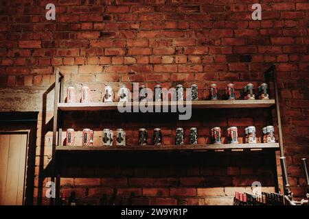 Newcastle upon Tyne: 20. Juli 2023: Wylam Brewery Taproom reiht Craft-Bier-Dosen zum Verkauf an eine rote Ziegelwand Stockfoto