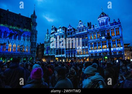 Brüssel, Belgien Dezember 2023 30. Große Menschenmassen beobachten die Sound- und Lichtshow im Grand-Place, Brüssel. Vom 24. November 2023 bis zum 7. Januar 2024 im Rahmen der Winter Wonders Veranstaltung. Die diesjährige 360°-Sound- und Lichtshow (6 bis 8 Minuten lang) basiert auf der Arbeit von Leilani Shaw, einer Künstlerin aus Kanien'kehá ka (Mohawk). Guy Bell/Alamy Live News Stockfoto