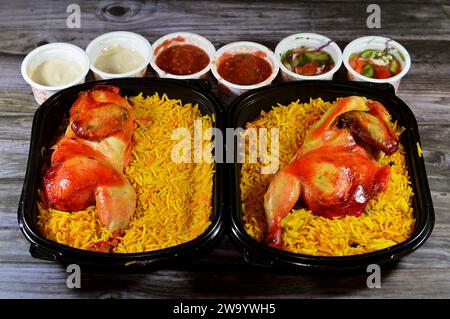 Kairo, Ägypten, 26. Dezember 2023: Hadramout Antar Restaurant Chicken mandi kabsa mit langem Basmatireis, serviert mit Tomaten-Dakos-Sauce, grünem Salat und Stockfoto