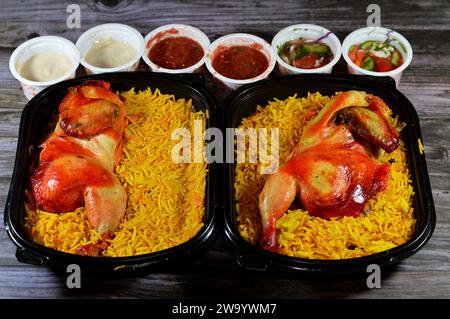 Kairo, Ägypten, 26. Dezember 2023: Hadramout Antar Restaurant Chicken mandi kabsa mit langem Basmatireis, serviert mit Tomaten-Dakos-Sauce, grünem Salat und Stockfoto