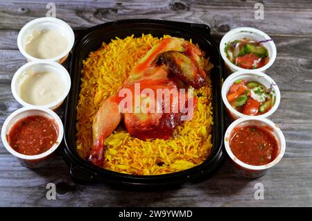 Kairo, Ägypten, 26. Dezember 2023: Hadramout Antar Restaurant Chicken mandi kabsa mit langem Basmatireis, serviert mit Tomaten-Dakos-Sauce, grünem Salat und Stockfoto