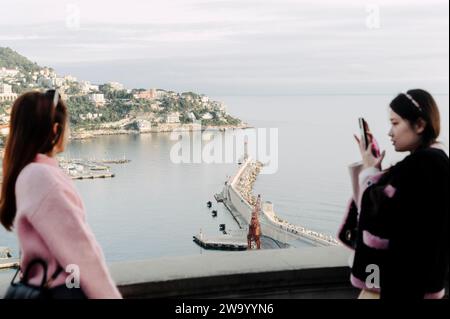 Nizza, Frankreich. Dezember 2023. Zwei Touristen fotografieren sich vor dem alten Stadthafen Stockfoto