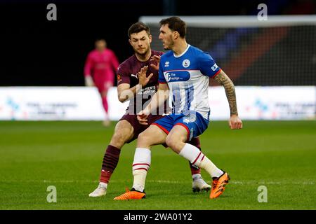 Nathan Sheron vom Oldham Athletic Association Football Club streift mit Callum Cooke vom Hartlepool United Football Club während des Vanarama National League-Spiels zwischen Oldham Athletic und Hartlepool United am Samstag, den 30. Dezember 2023, im Boundary Park in Oldham. (Foto: Thomas Edwards | MI News) Stockfoto