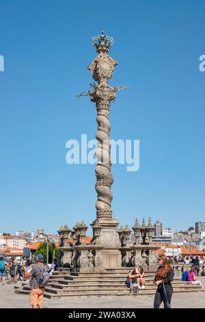 Touristen, die das historische Monument Pillory oder Pelourinho do Porto besuchen, eine hohe Granitsäule direkt vor der Kathedrale in Porto, Portugal Stockfoto