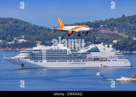 Skiathos, Griechenland - 24. August 2023: EasyJet A320 mit einem Boot im Hintergrund nähert sich dem Flughafen Skiathos Stockfoto