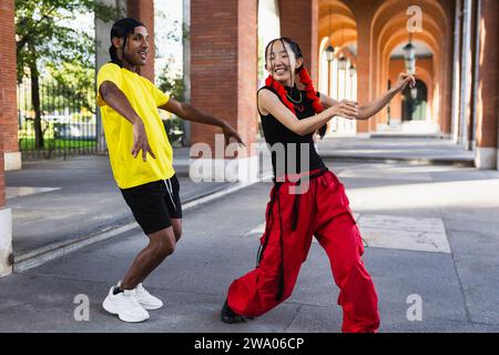 Junges multirassisches Paar tanzt Afro-Tanz auf der Straße und hat Spaß Stockfoto