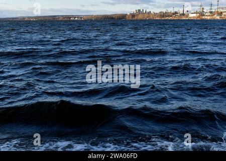 Schwarze Wellen des Stausees im Winter in den Bergen. Das dunkle Wasser des Stausees in Jekaterinburg. Stockfoto