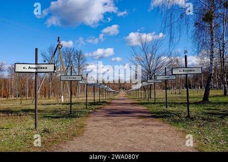 Eine ländliche Landschaft mit einem weiten Blick auf den Weg und die Schilder. Gasse mit den Namen verlassener Dörfer in der Zone der Tschernobyl-Atomkatastrophe Stockfoto