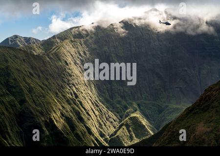 Der Hubschrauber ragt über die grünen West Maui Mountains, von Waihe'e Ridge aus gesehen. Stockfoto