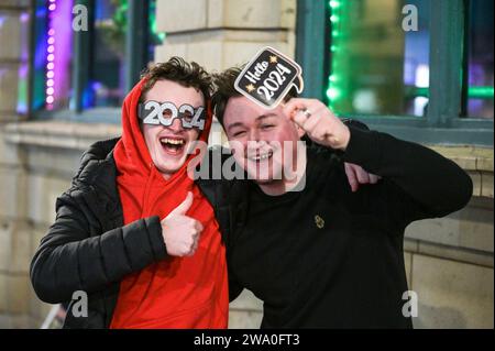 Broad Street, Birmingham, 31. Dezember 2023: Rain konnte die Stimmung nicht dämpfen, als die Revellers Silvester auf der Broad Street in Birmingham feierten. Die Partygäste machten sich früh auf, um den Eintritt vor Mitternacht zu garantieren, als die Feierlichkeiten begannen. Quelle: Stop Press Media/Alamy Live News Stockfoto