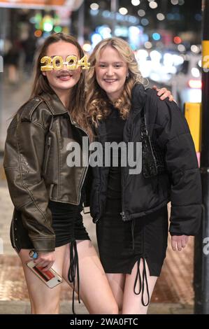 Broad Street, Birmingham, 31. Dezember 2023: Rain konnte die Stimmung nicht dämpfen, als die Revellers Silvester auf der Broad Street in Birmingham feierten. Die Partygäste machten sich früh auf, um den Eintritt vor Mitternacht zu garantieren, als die Feierlichkeiten begannen. Quelle: Stop Press Media/Alamy Live News Stockfoto