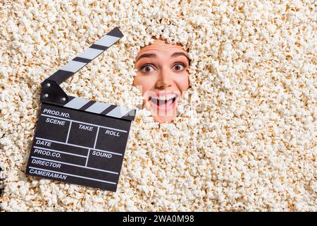 Oben sehen Sie Foto von funky fröhlich erstaunten Mädchen Klatschbrett Gesicht isoliert innerhalb Popcorn Hintergrund Stockfoto