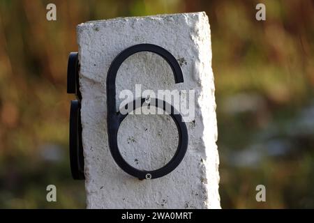 Zahl, Zahl, 6, sechs, Stein, Hausnummer, Ziffer, weiß, Metall, die Nummer sechs ist mit Schrauben an einem weißen Stein befestigt Stockfoto