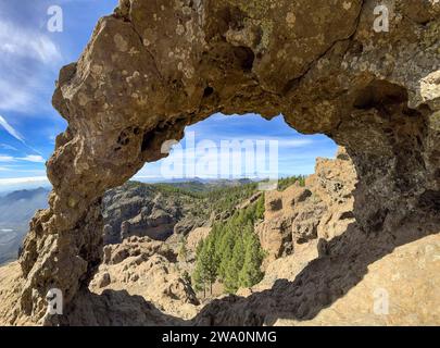 Blick durch einen Felsbogen auf den Roque Nublo und den Teide-Gipfel auf der Nachbarinsel Teneriffa, Pico de las Nieves, Gran Canaria, Kanarischen Inseln I Stockfoto