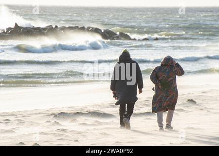 Zwei Frauen laufen bei stürmischem Wetter am Strand entlang in Ystad, Skanien, Ostsee, Schweden, Skandinavien, Europa Stockfoto