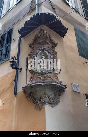 Skulptur der Jungfrau Maria unter einem Baldachin in einem Eckhaus im historischen Zentrum von Genua, Italien, Europa Stockfoto