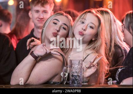 Broad Street, Birmingham, 31. Dezember 2023: Rain konnte die Stimmung nicht dämpfen, als die Revellers Silvester auf der Broad Street in Birmingham feierten. Einige wurden jedoch von ihren Freunden beobachtet, die vor Mitternacht ein Taxi nach Hause bestellten. Die meisten Partygäste machten sich früh auf, um den Eintritt vor Mitternacht zu garantieren, als die Feierlichkeiten begannen. Quelle: Stop Press Media/Alamy Live News Stockfoto