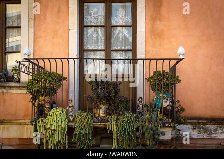 Dekorierter Balkon mit Köpfen und Sukkulenten in Taormina auf einer Felsterrasse am Hang des Monte Tauro, Sizilien, Italien Stockfoto