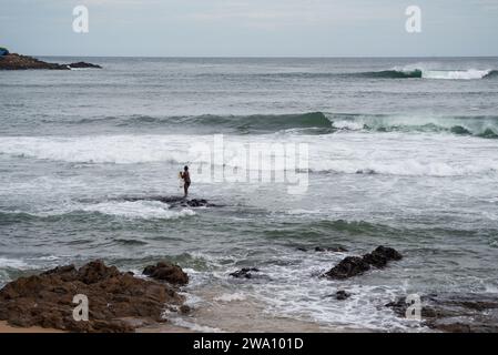 Salvador, Bahia, Brasilien - 29. Januar 2022: Fischer werfen Fischernetze am Strand von Rio Vermelho in Salvador, Bahia. Stockfoto