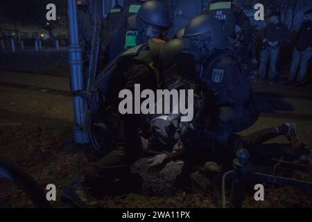 Berlin, Deutschland. Januar 2024. Gleichzeitig wurde am 1. Januar 2024 in einem separaten Vorfall in der Knobelsdorffstraße in Berlin-Charlottenburg Polizei in Aufruhrausrüstung eingesetzt, um Störungen während der Silvesterfeier zu bewältigen. Ein Foto von der Szene fängt den Moment ein, in dem die Polizei mehrere Personen festnimmt, während das Chaos der Nacht sich in den Lichtern der Rettungsfahrzeuge widerspiegelt. Die Reaktion der Polizei wurde durch Berichte über widerspenstiges Verhalten bei einigen Partygängern ausgelöst, einschließlich des gefährlichen Einsatzes von Feuerwerkskörpern. (Bild: © Michael Kuenne/PRESSCOV via ZUMA Press Wire) EDI Stockfoto