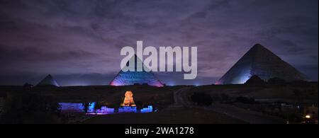 Gizeh, Ägypten - 24. Dezember 2023: Die Pyramiden und die Sphinx in den Nachtlichtern Stockfoto