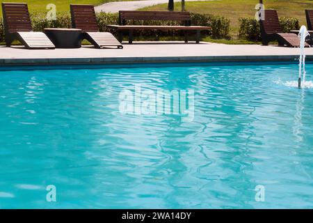 Holzstuhl und Tisch in der Nähe des Pools. Leerer Platz am Pool, Sommerhintergrund. Stockfoto
