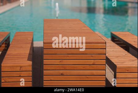 Holzstuhl und Tisch in der Nähe des Pools. Leerer Platz am Pool, Sommerhintergrund. Stockfoto