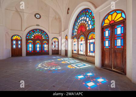 Zimmer mit bunten Buntglasfenstern im Tabatabaei House, einem historischen Herrenhaus, das um 1880 in Kaschan, Iran, erbaut wurde. Stockfoto