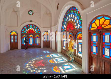 Zimmer mit bunten Buntglasfenstern im Tabatabaei House, einem historischen Herrenhaus, das um 1880 in Kaschan, Iran, erbaut wurde. Stockfoto