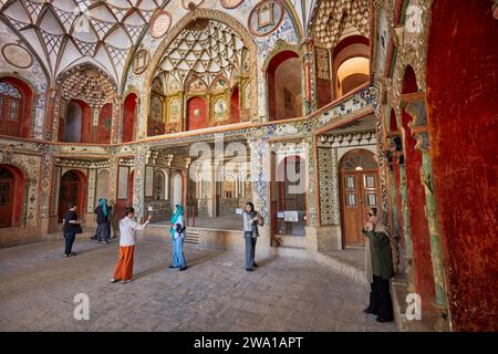 Touristen besuchen die Haupthalle im Borujerdi-Haus, ein traditionelles reiches persisches Haus, das 1857 erbaut wurde. Kaschan, Iran. Stockfoto