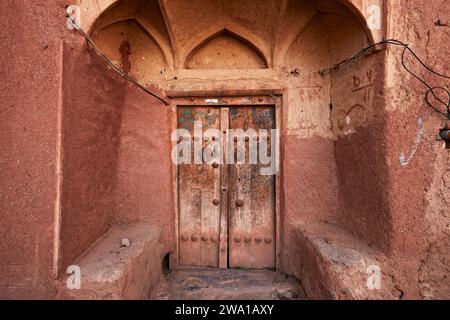 Alte hölzerne Eingangstür eines traditionellen Hauses im historischen Dorf Abyaneh, Natanz County, Iran. Stockfoto