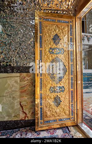 Goldene Tür im Imamzadeh Mohammed Helal Schrein, aufwendig mit komplizierten Prägungen und islamischer Kalligraphie verziert. Aran o Bidgol, Iran. Stockfoto