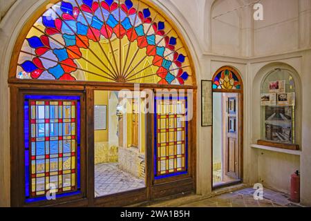 Zimmer mit bunten Buntglasfenstern im Taj House, historisches Herrenhaus aus dem 19. Jahrhundert in Kashan, Iran. Stockfoto