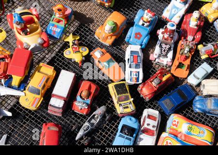Alle Arten von billigen bunten alten Metall- und Plastik-Minispielzeugautos auf einem Flohmarkt in Maastricht, von oben gesehen Stockfoto