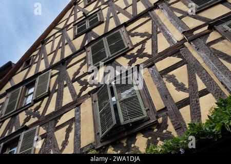 Fassade eines farbenfrohen traditionellen Fachwerkhauses mit Fensterläden in der Rue du Général-de-Gaulle in Riquewihr, Elsass, Frankreich Stockfoto